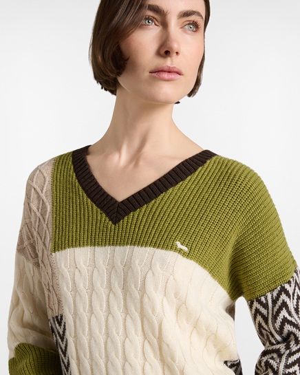 A women's Harmont & Blaine patchwork sweater featuring a cable-knit pattern and geometric inserts in olive green, cream white, and brown tones, with a V-neck finished with dark ribs and the small dachshund logo on the chest, in an image focused on the women's knitwear category.
