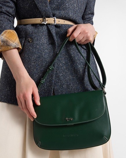 A vibrant green leather shoulder bag featuring distinct contrast stitching and a polished silver dachshund logo. A sophisticated accessory, perfect for an everyday stylish look, specializing in the women's bags category.