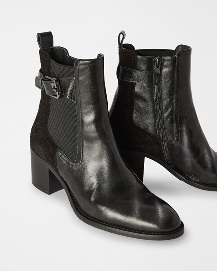 A pair of women's black Harmont & Blaine ankle boots featuring a mid-heel, a shiny leather upper with suede details, embellished with a side buckle and a practical zipper, in an image focused on the women's footwear category.