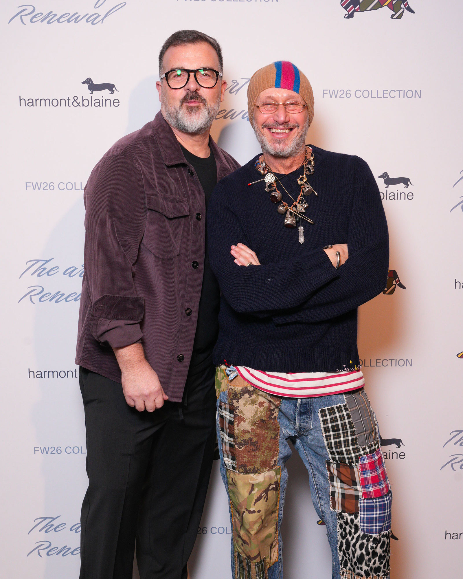 Deux hommes en looks d&eacute;contract&eacute;s, l&rsquo;un en veste en velours violette, l&rsquo;autre en pull marine et pantalon patchwork