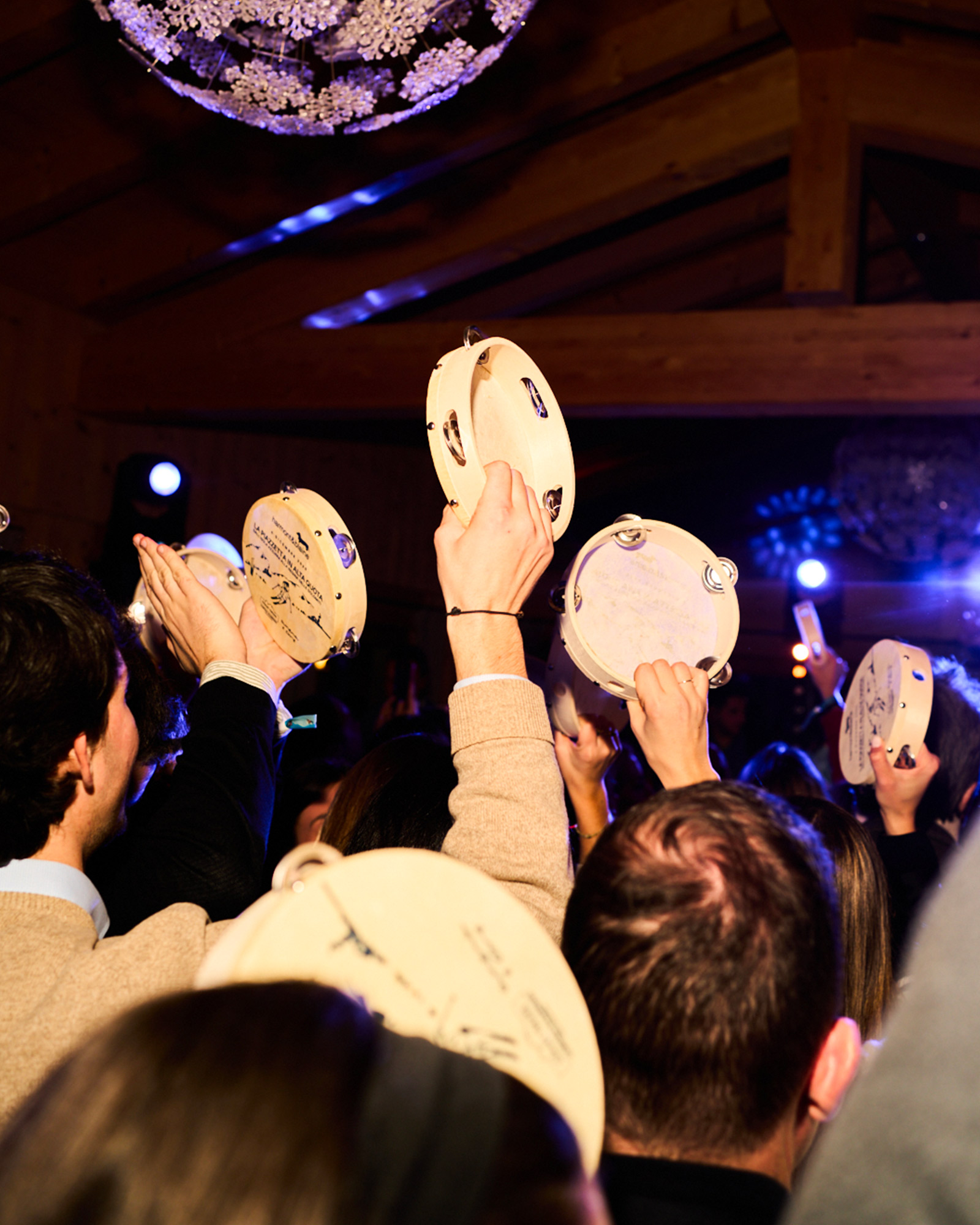Audience raising tambourines during the live performance.