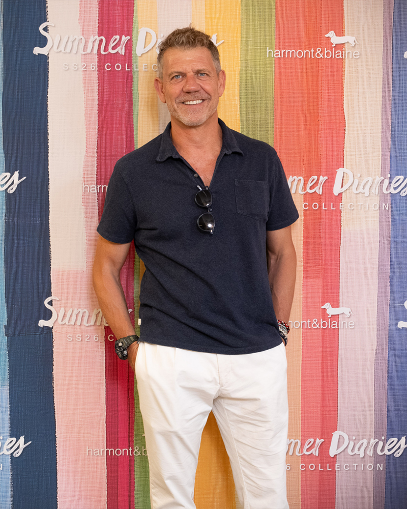 Man posing in front of Summer Diaries backdrop.