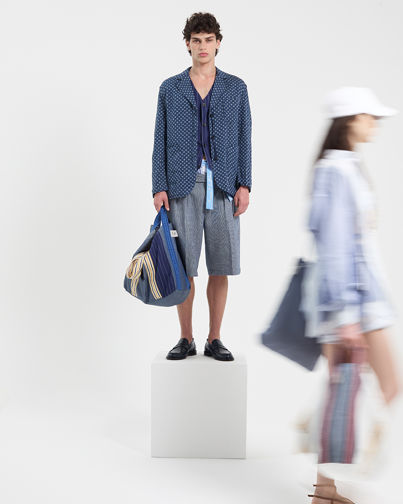 Male model wearing blue jacket and shorts from summer collection.