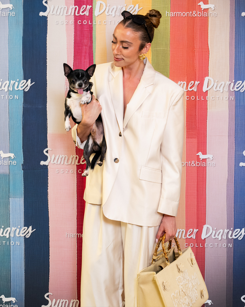 Stylish woman with dog at Harmont & Blaine Summer Diaries event.